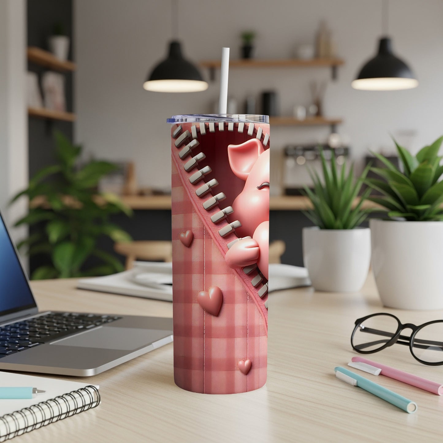 Pink pig peeking from a zippered pink plaid tumbler on a desk.