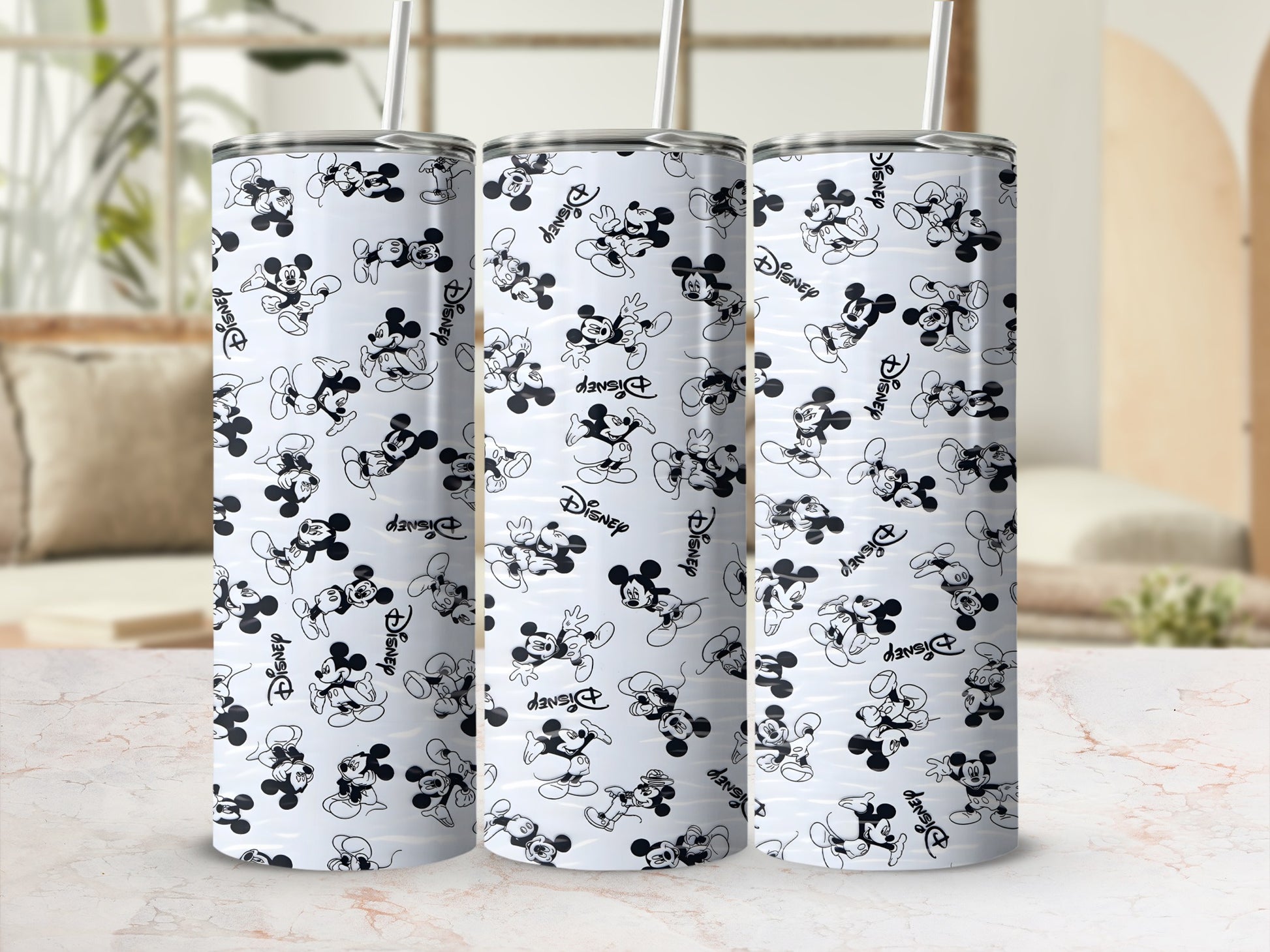 Three Disney Mickey Mouse tumblers with straw, patterned with black and white Mickey Mouse figures and "Disney" text.