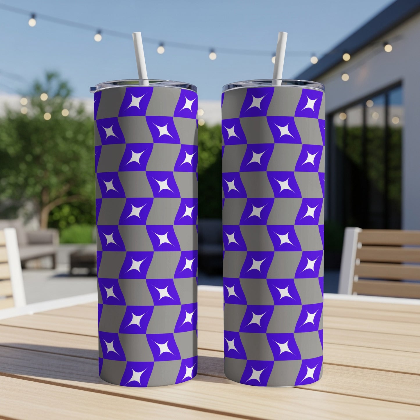 Two purple and gray geometric pattern tumblers with straws on a wooden table.