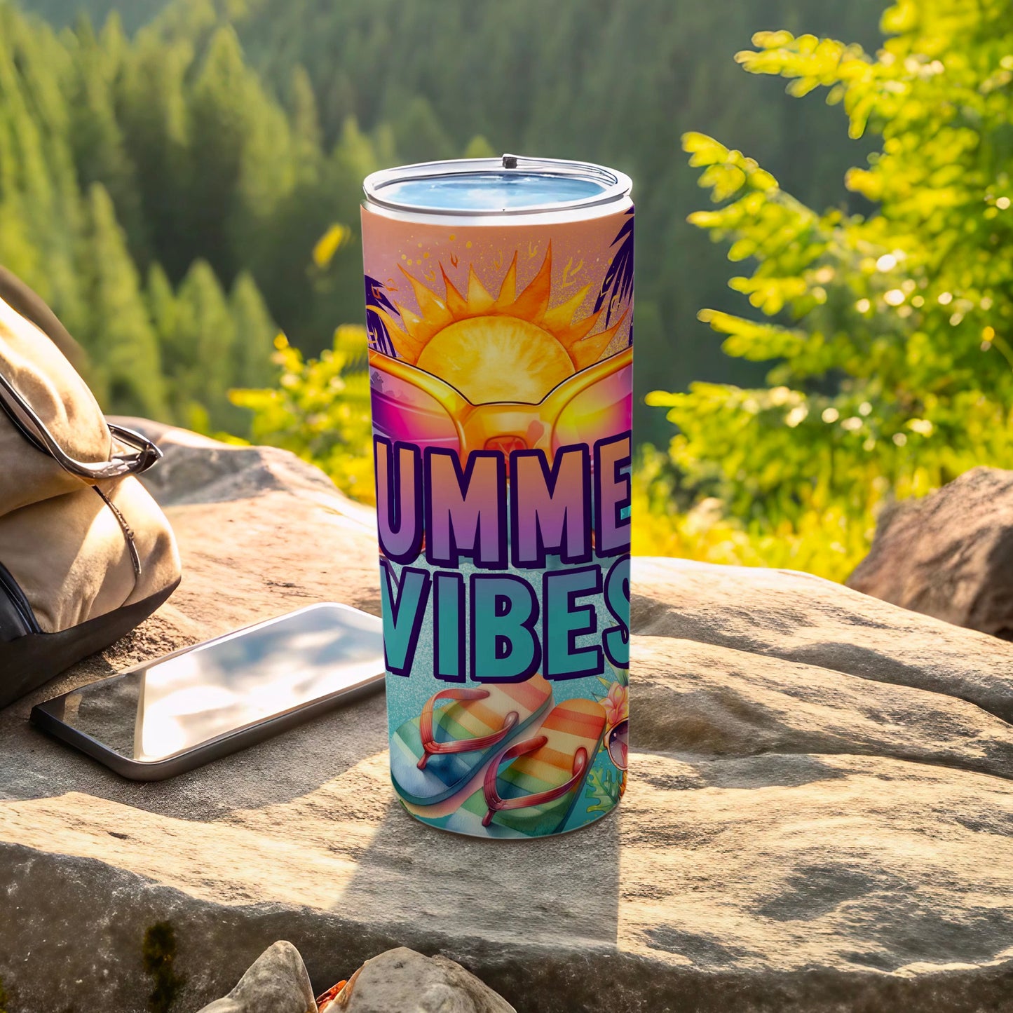 Tumbler with "Summer Vibes" text and flip-flops on a rocky surface.