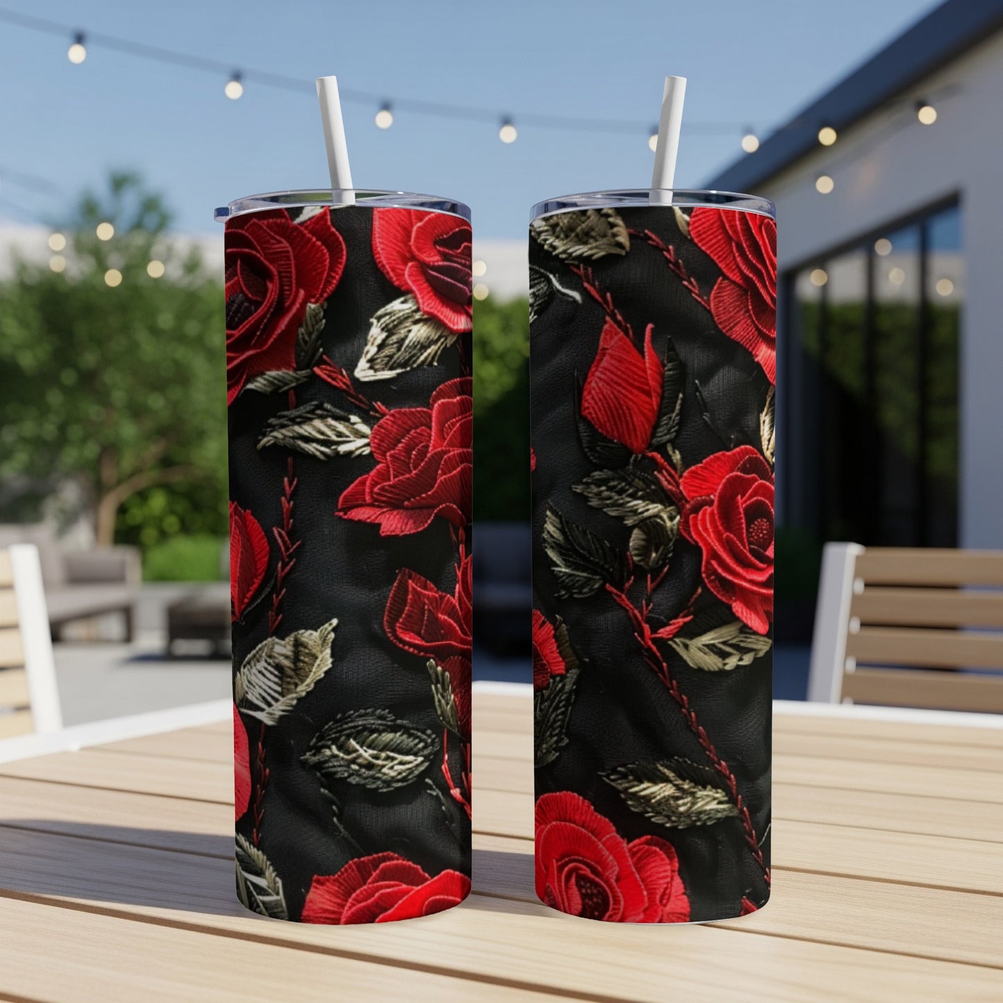 Two tall tumblers with red rose floral pattern on a wooden table.
