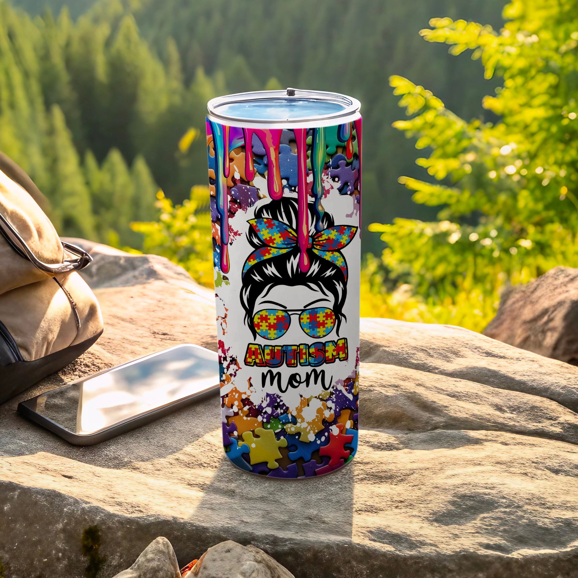 Autism mom tumbler with puzzle pieces and colorful dripping paint design.