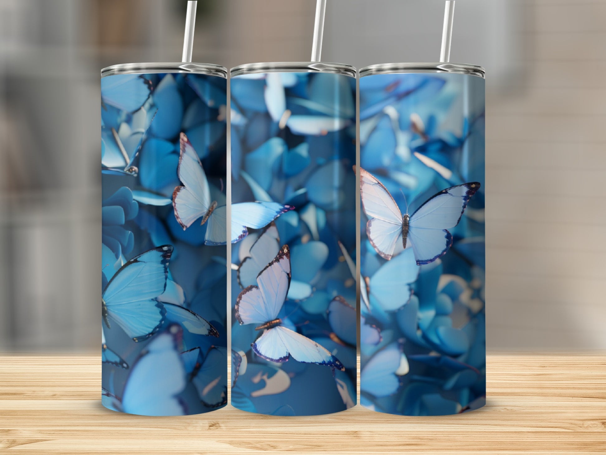 Three blue butterfly tumblers arranged in a row on a wooden surface.