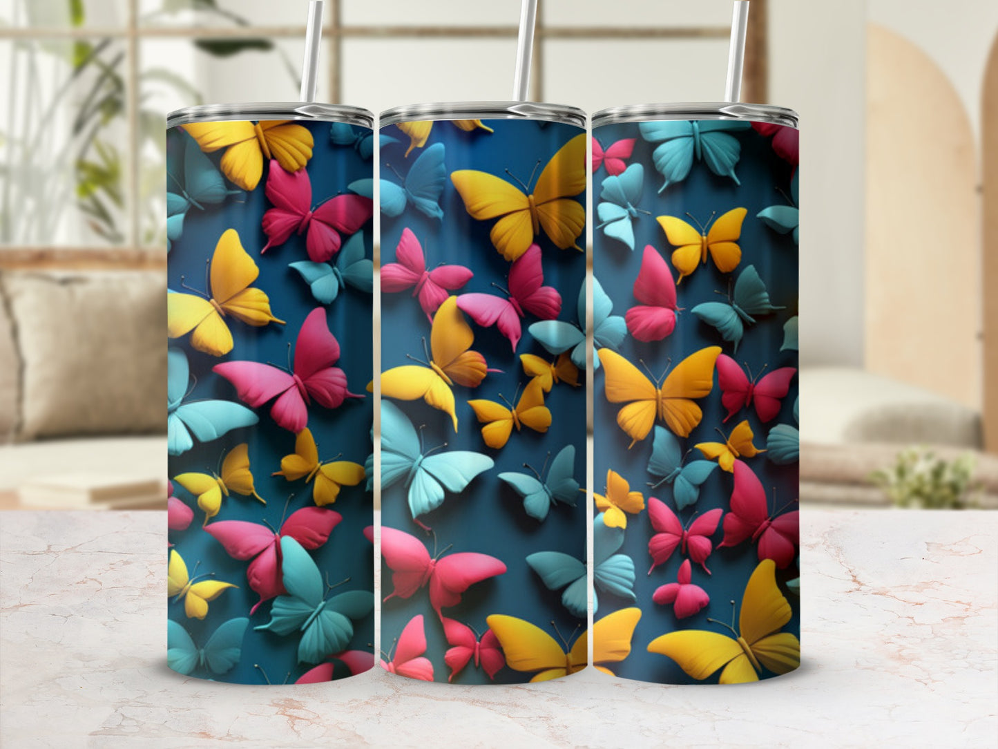 Three tumblers adorned with colorful butterflies on a teal background.