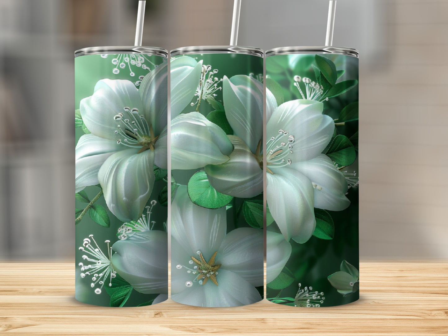 Three green tumblers with white floral designs on a wooden surface.