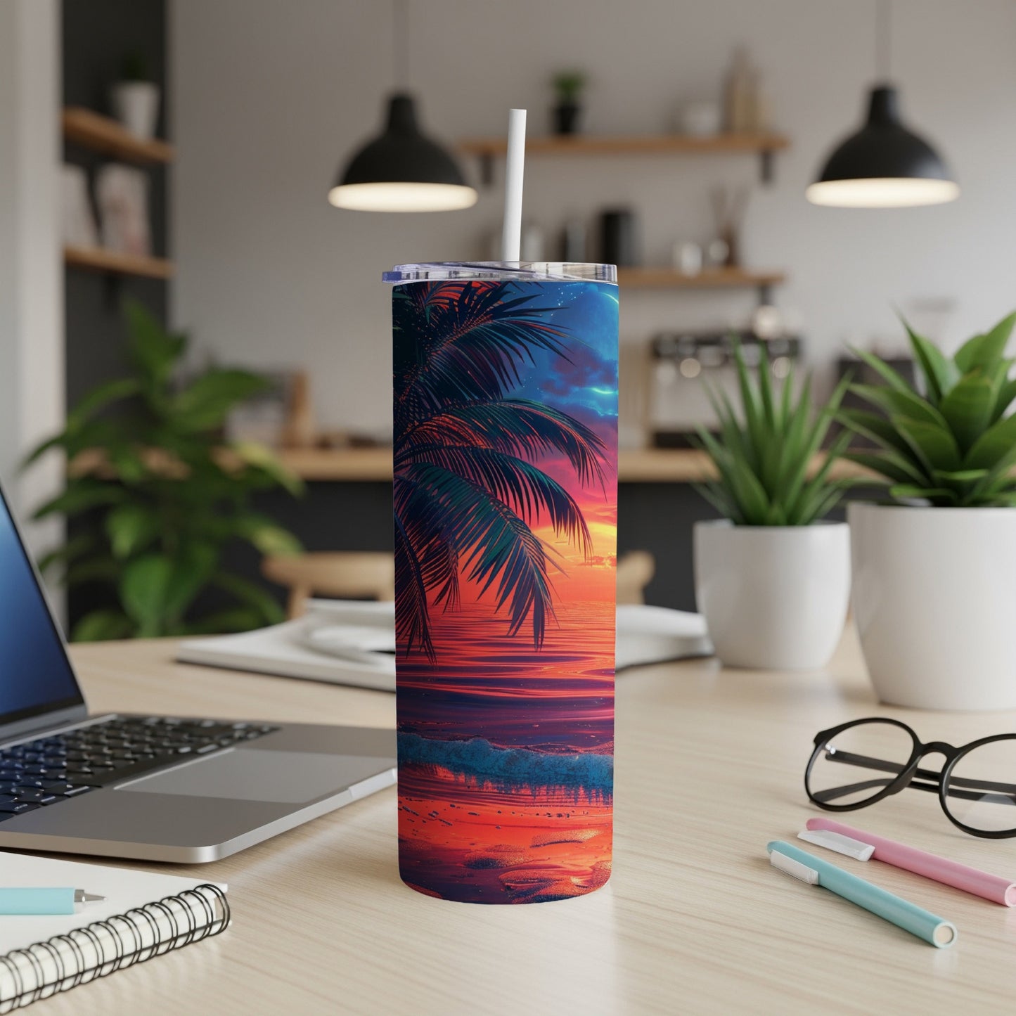Tropical sunset scene on a stainless steel tumbler with a white straw.