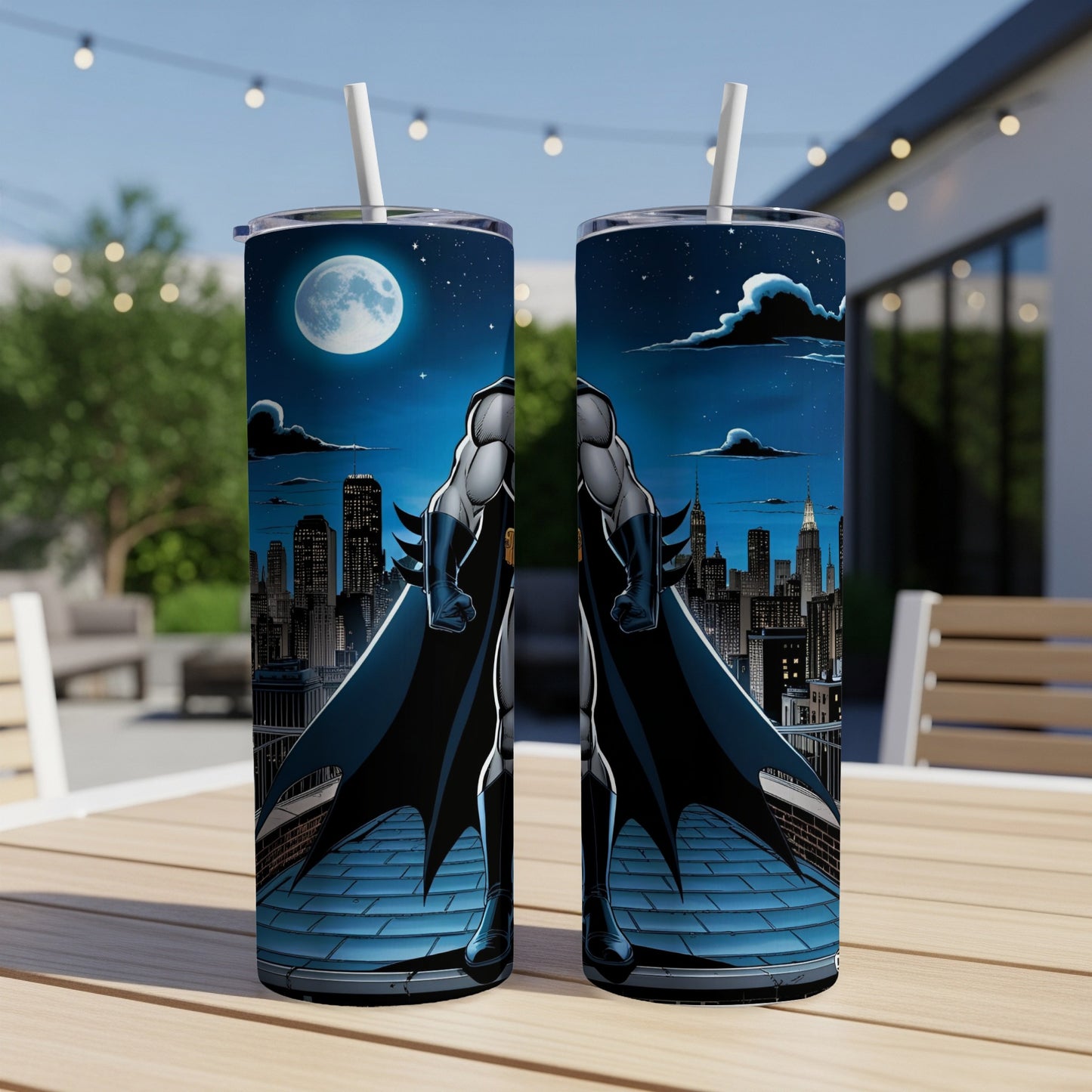Two Batman tumblers on a table with a city skyline and moon in the background.