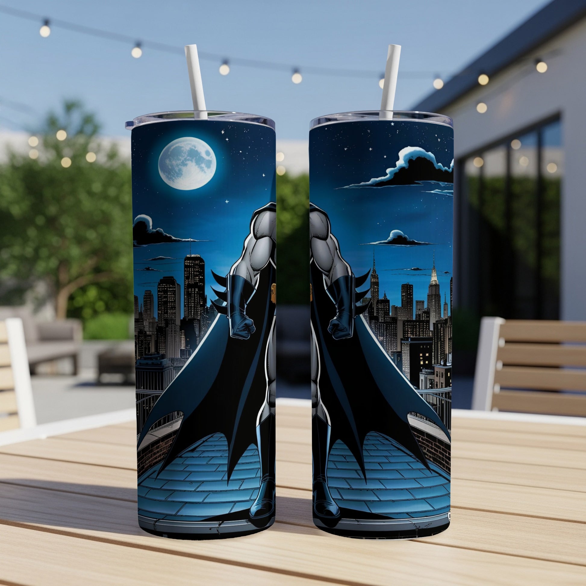 Two Batman tumblers on a table with a city skyline and moon in the background.