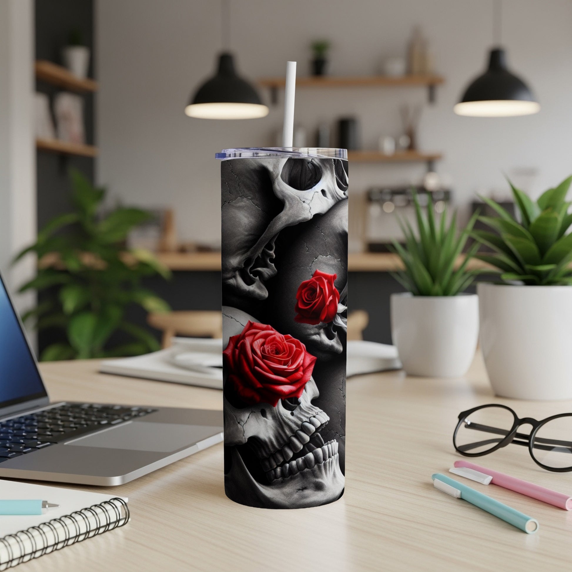 Tall tumbler with skulls and red roses design, straw inserted.