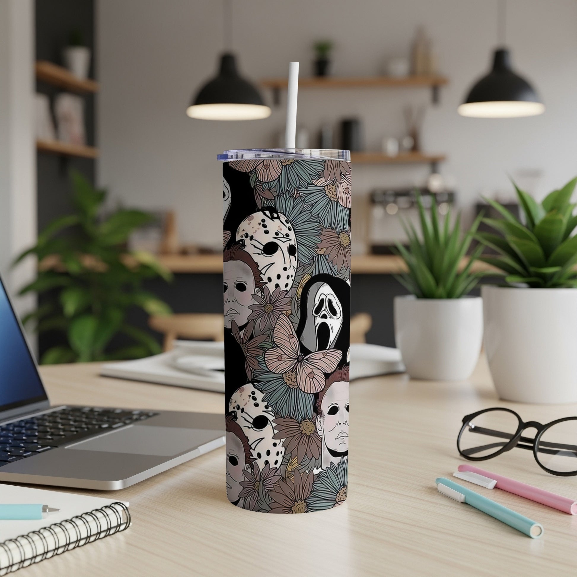Tall tumbler with horror movie masks and floral pattern.