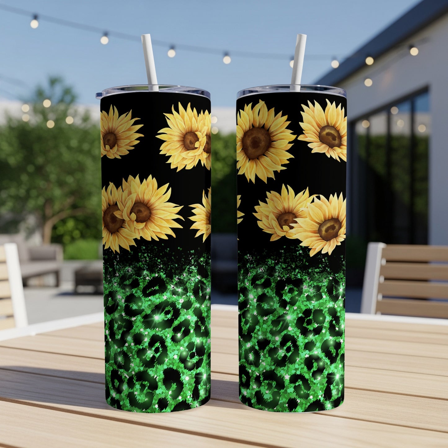 Two tumblers with sunflowers and green leopard print on a patio table.