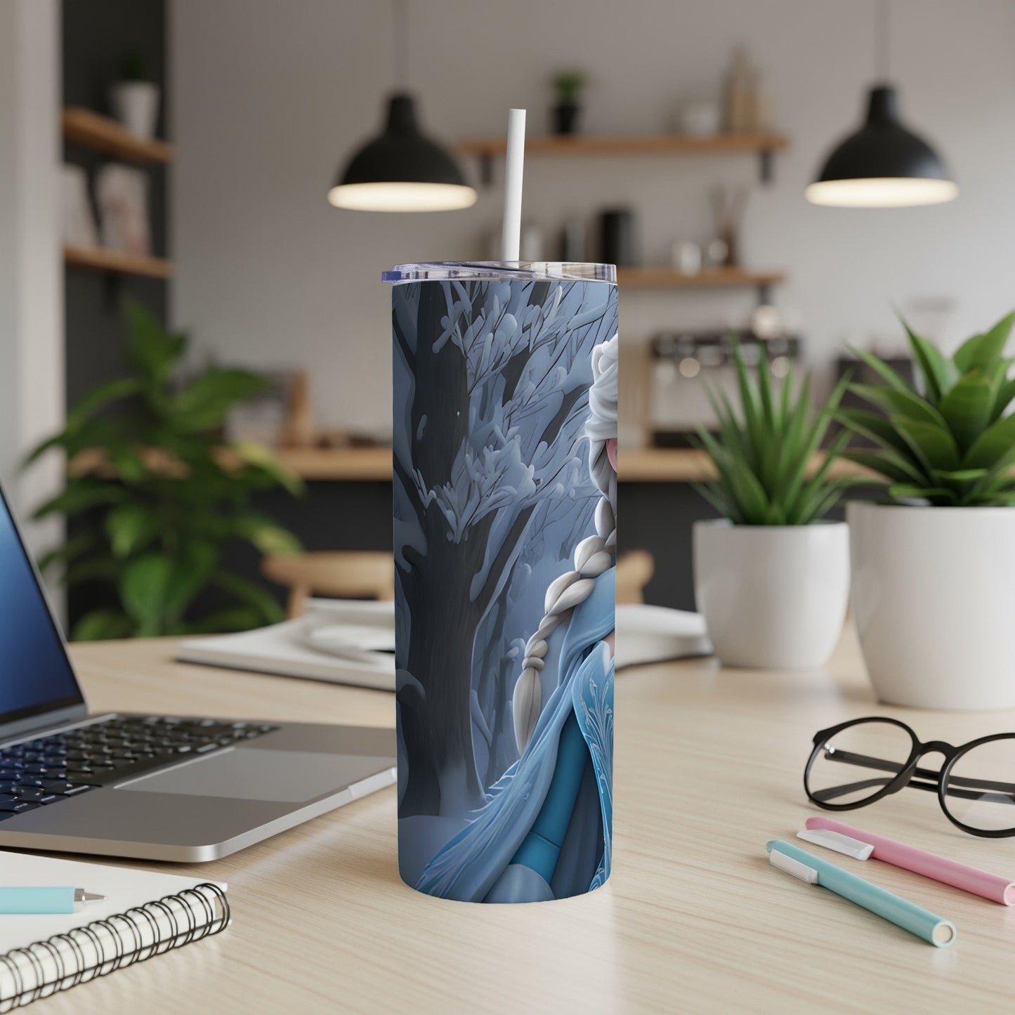 Frozen Elsa on a blue and white tumbler with a straw, on a desk.