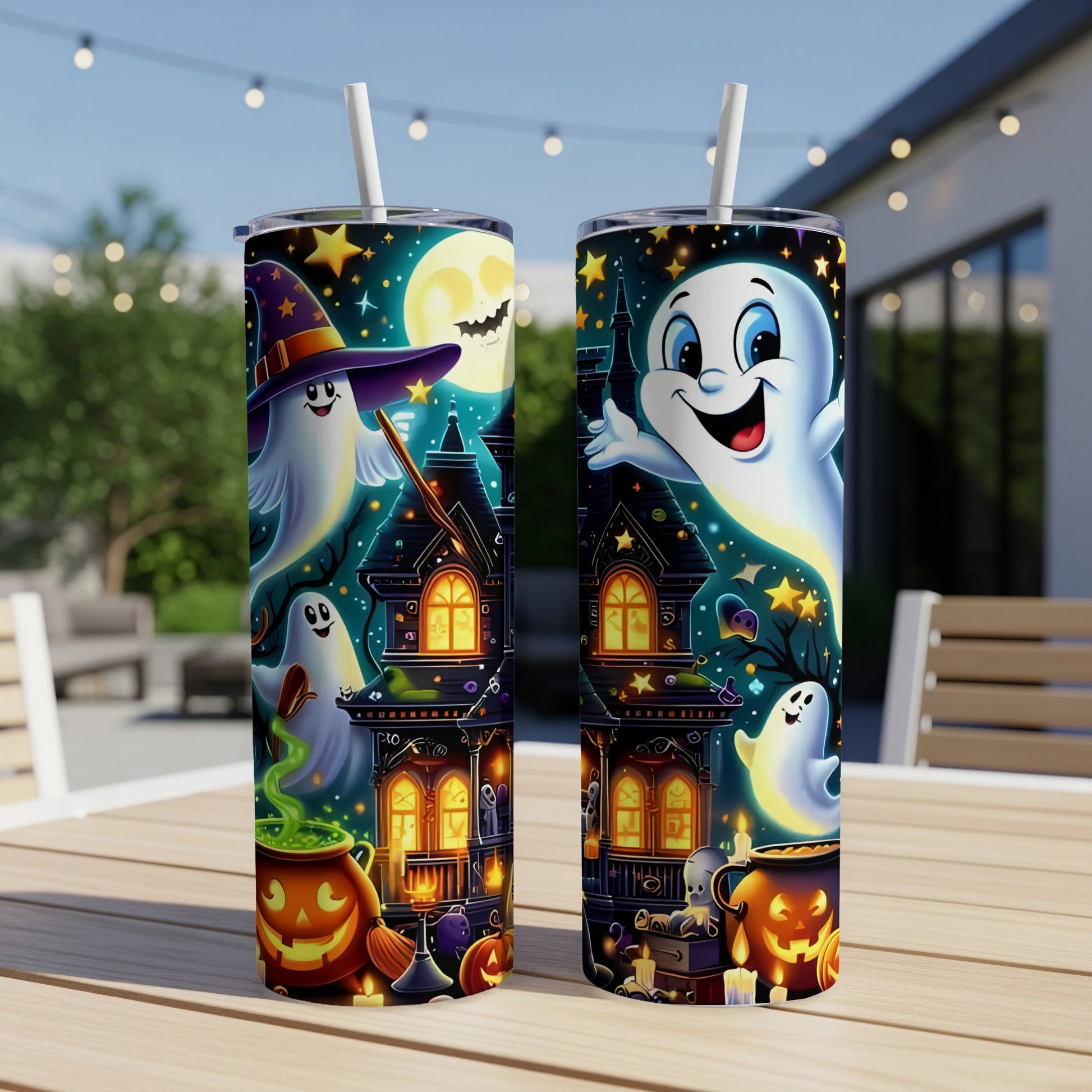 Two Halloween tumblers with ghosts, haunted houses, and pumpkins on a wooden table.