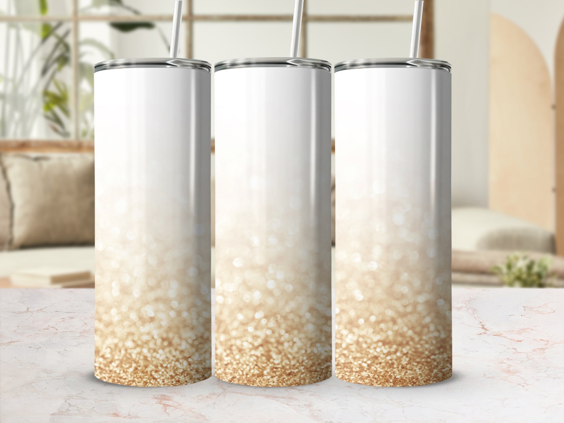 Three white tumblers with gold glitter gradient, against a blurred background.