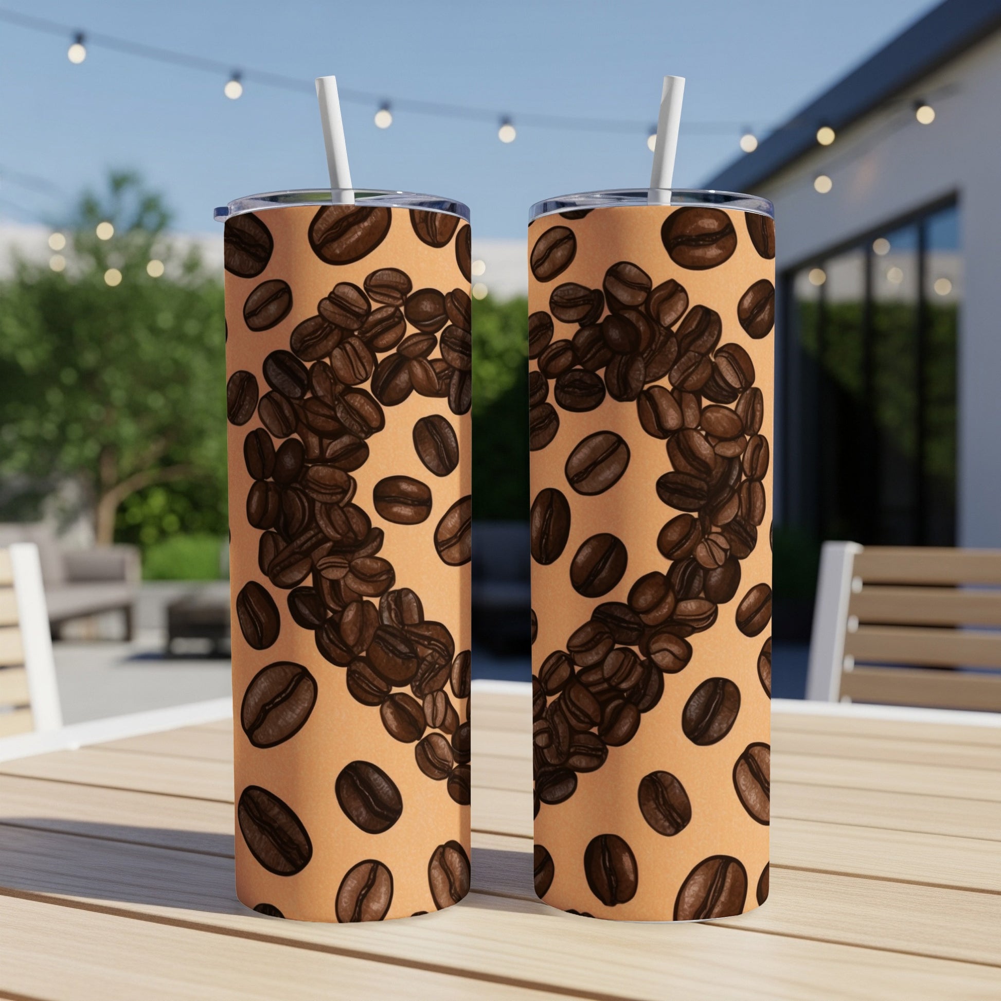 Two coffee tumblers with coffee bean pattern, sitting on a table outdoors.