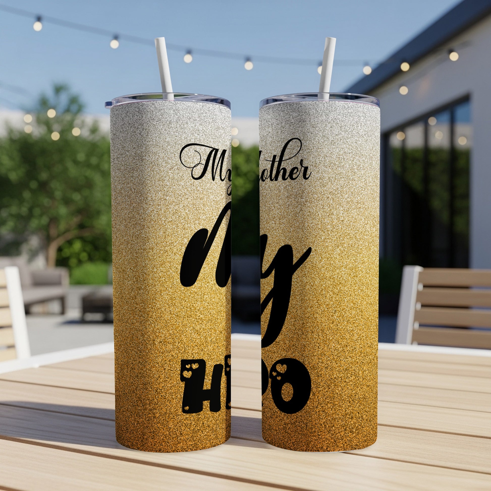 Two glitter tumblers with "My Mother, My Hero" text on a patio table.
