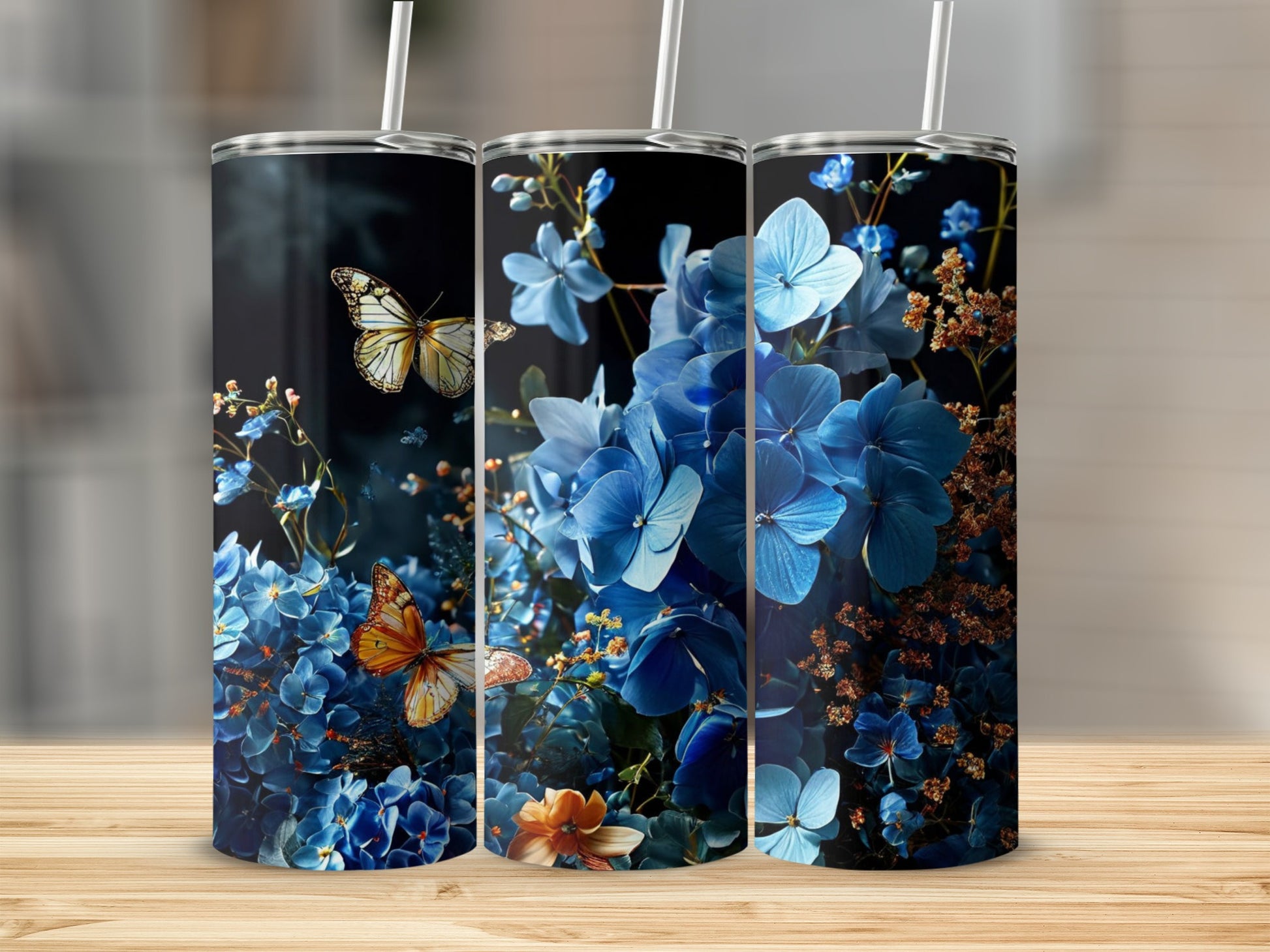 Three tumblers with blue hydrangeas and butterflies, one with a straw.