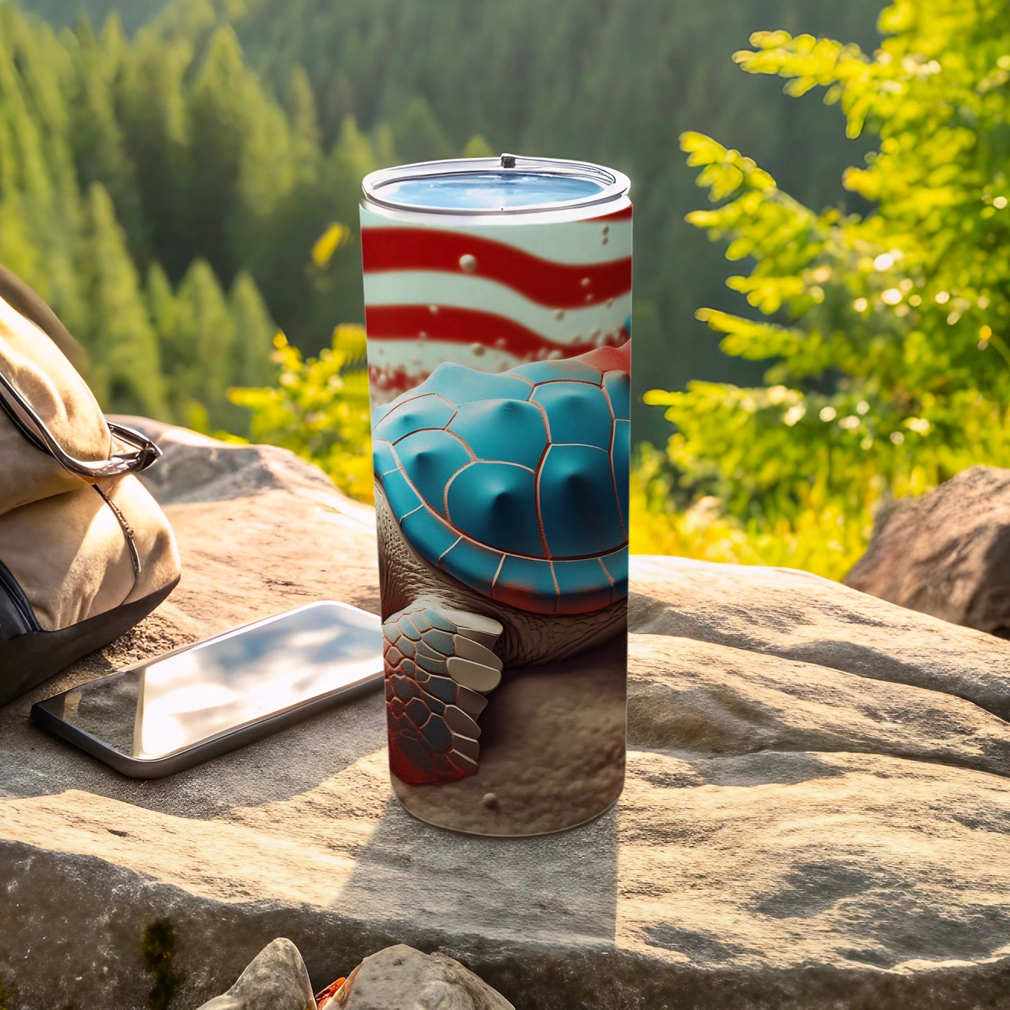 Tumbler with turtle and American flag design on outdoor rocky surface.