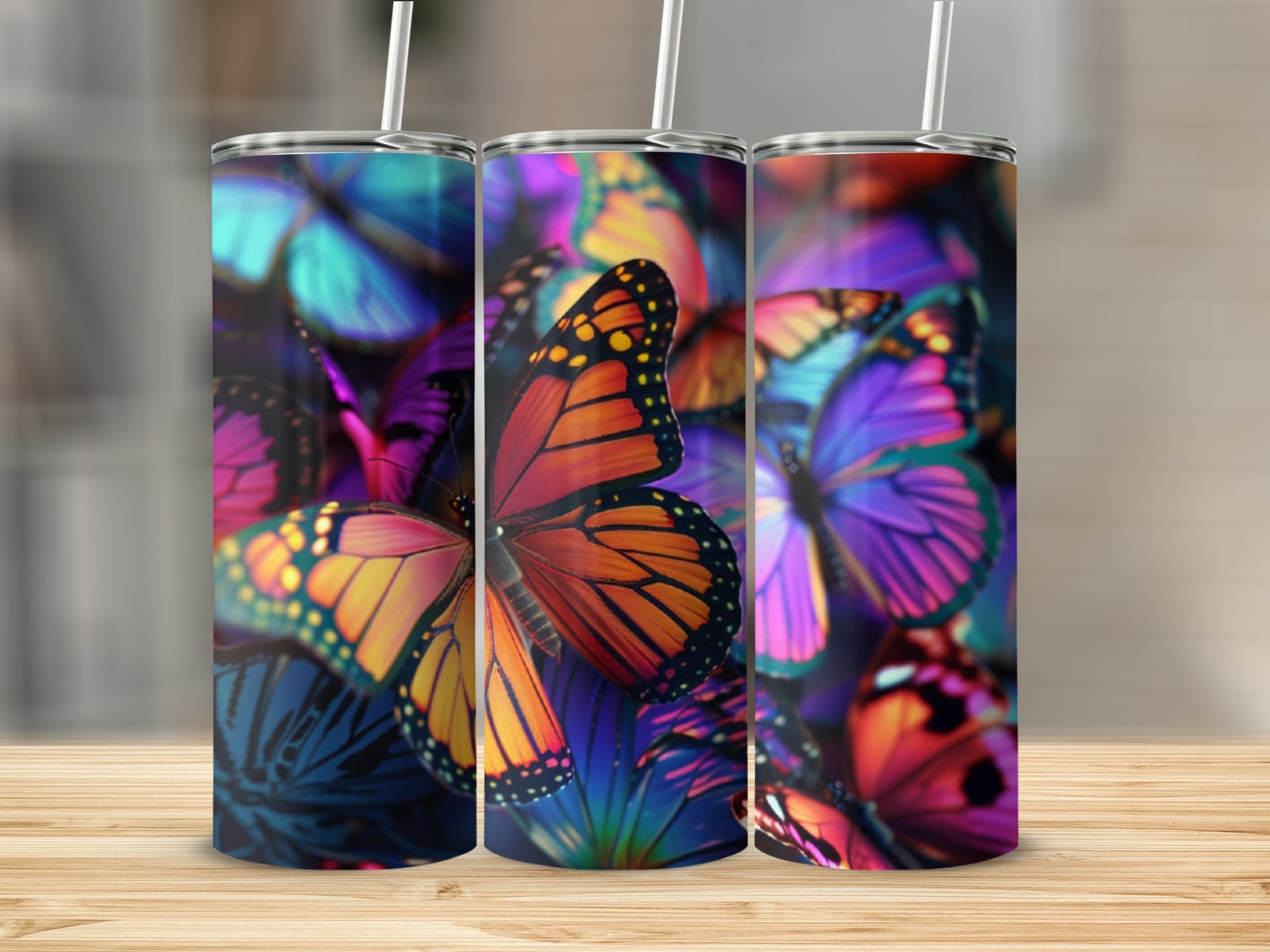 Three tumblers with colorful monarch and blue morpho butterfly designs.