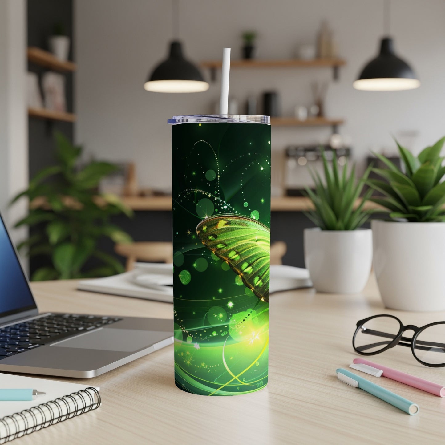 Green butterfly on a dark green speckled tumbler with white straw.