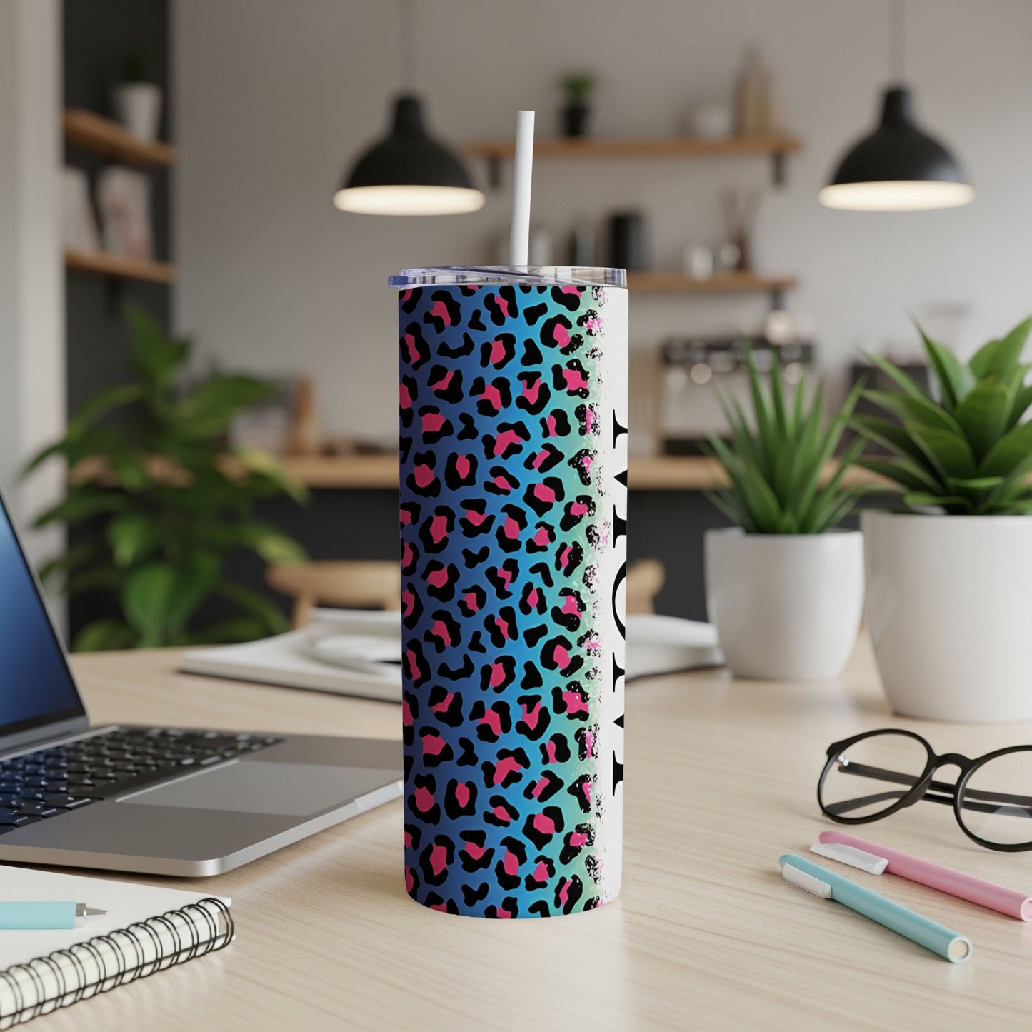 Leopard print tumbler with straw on a desk with laptop.