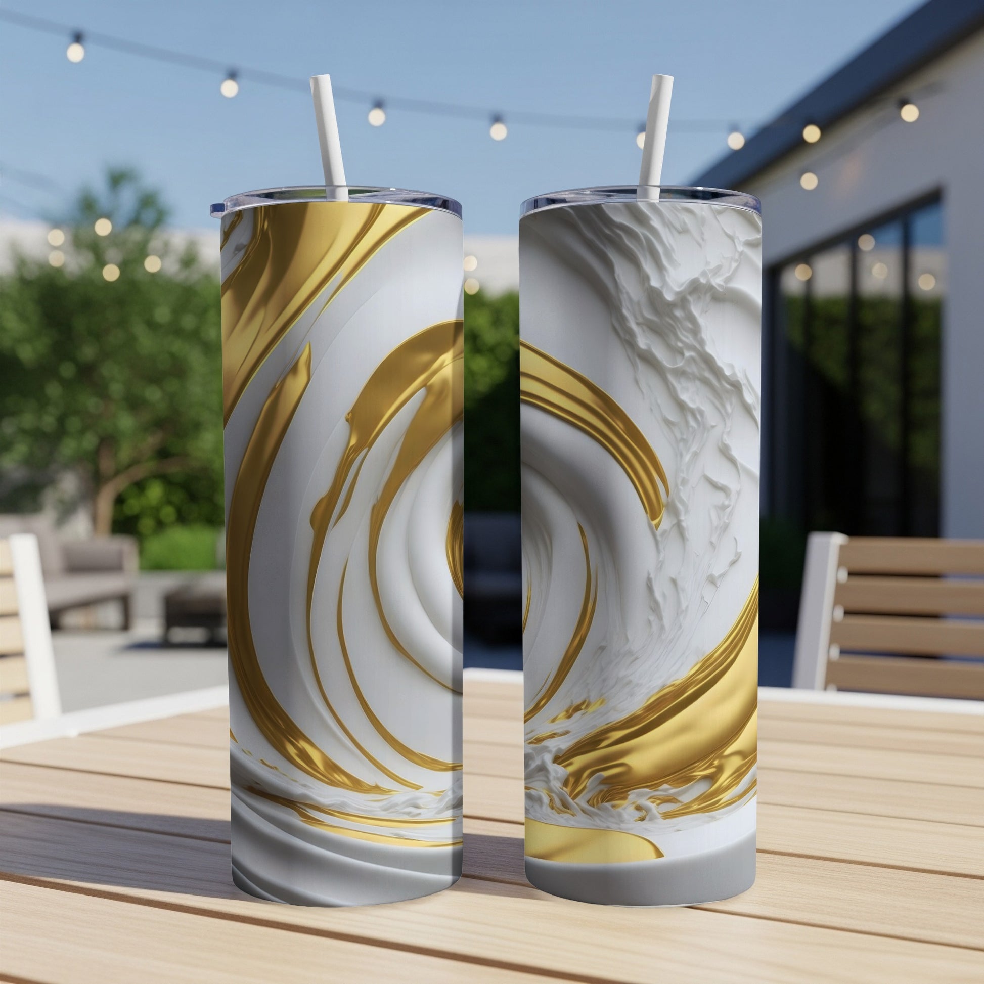 Two tall, white tumblers with swirling gold and white abstract patterns, with straws.