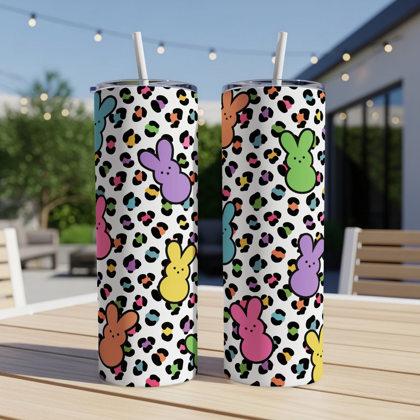 Two Easter bunny tumblers with leopard print on an outdoor table.