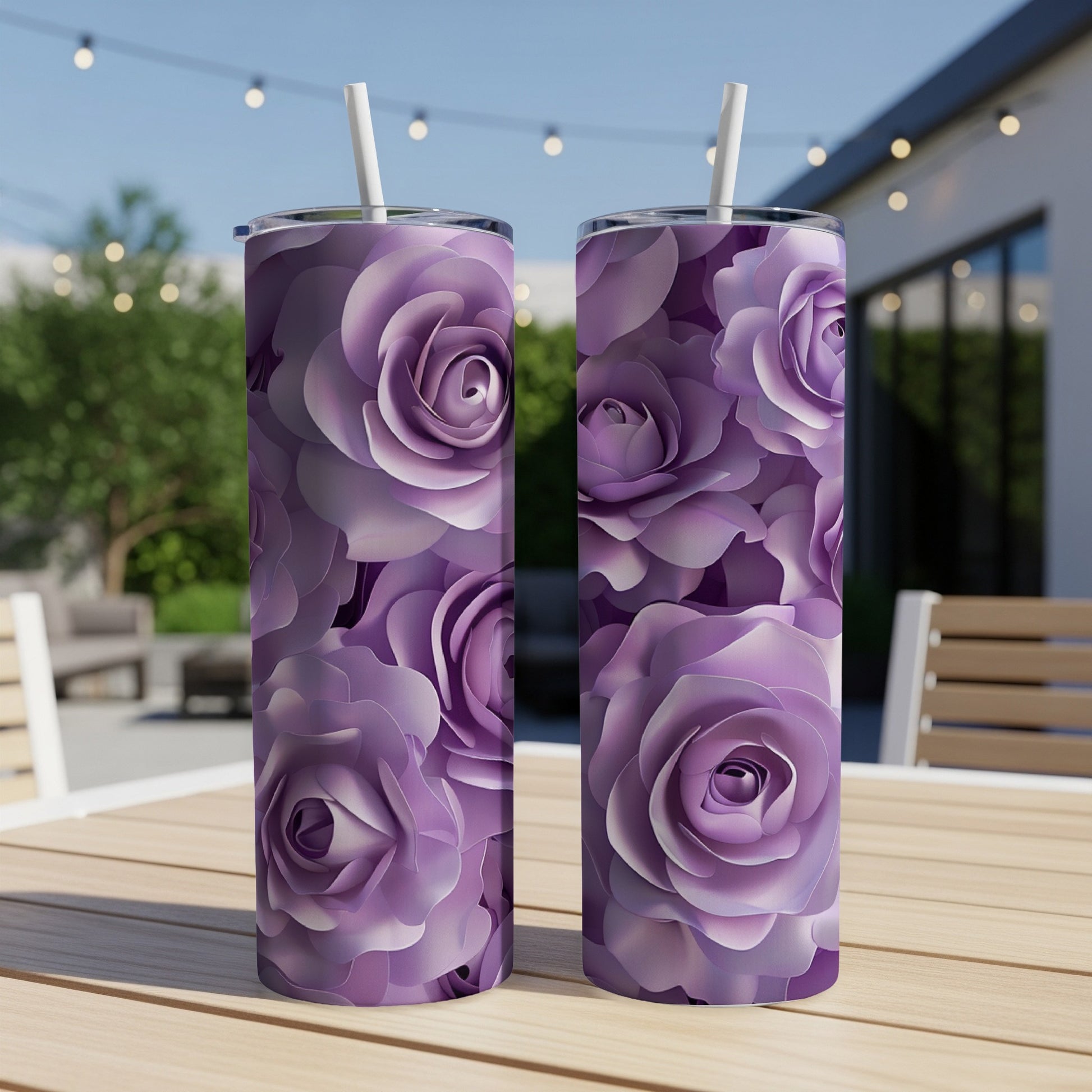 Two purple rose patterned tumblers on a wooden table outdoors.