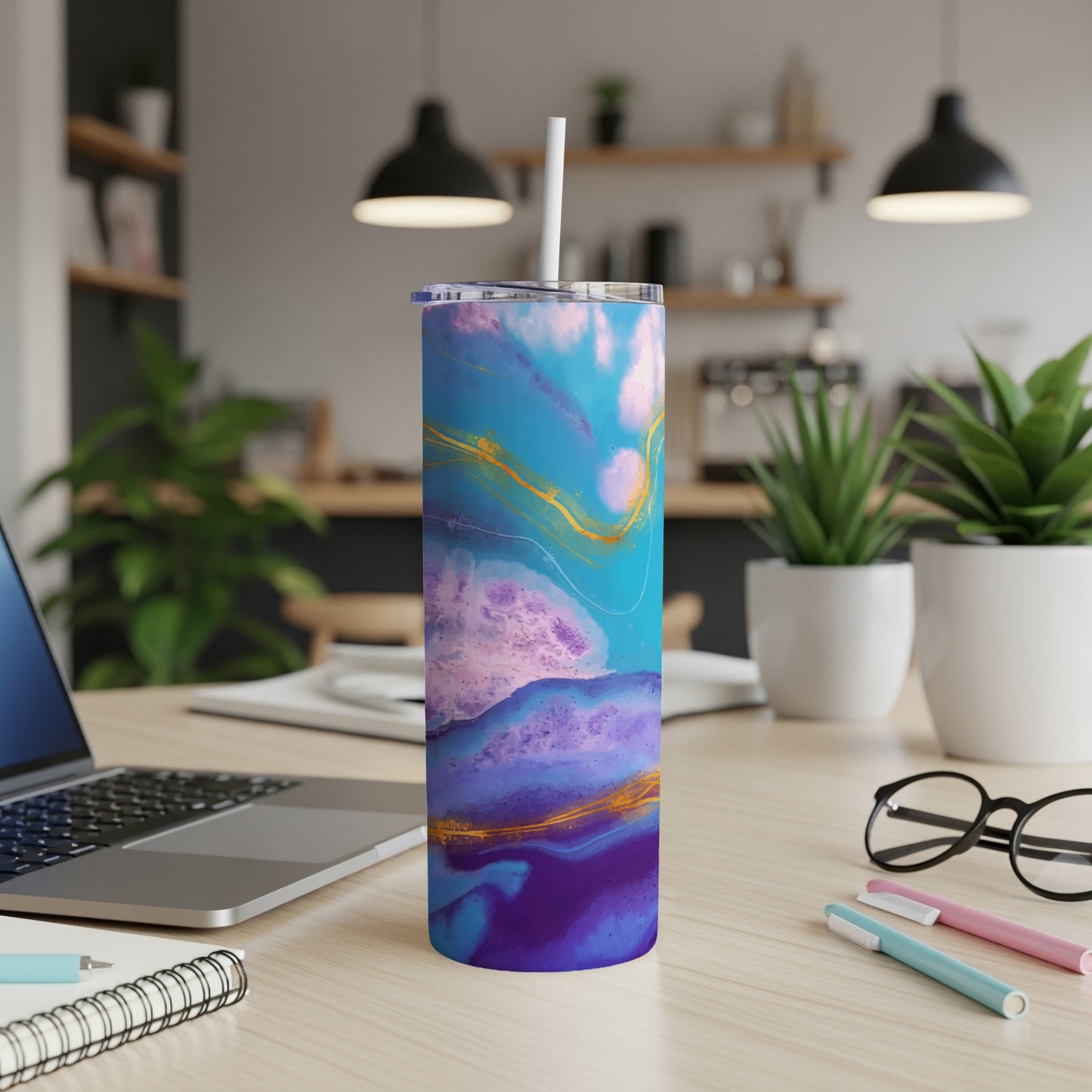Tumbler with abstract blue and purple art design and gold accents, with straw.