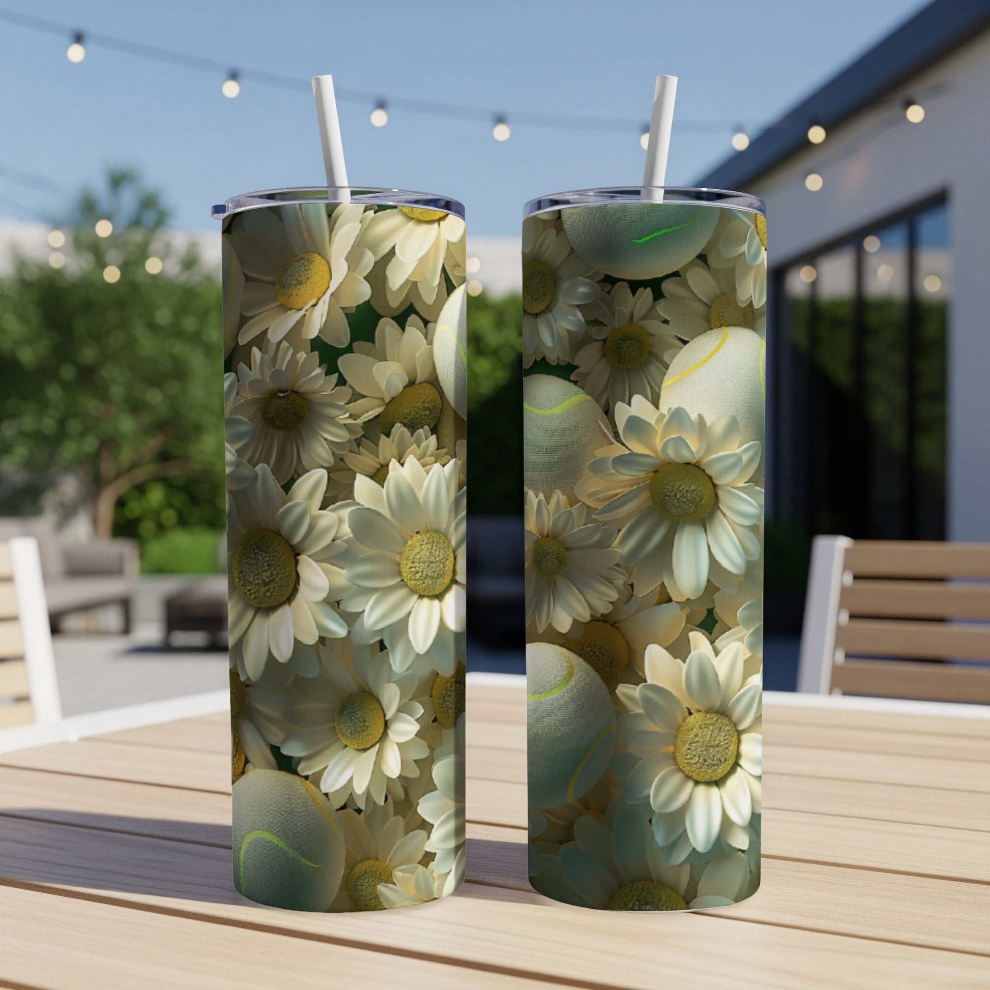 Two tall tumblers with a floral and tennis ball pattern on an outdoor table.