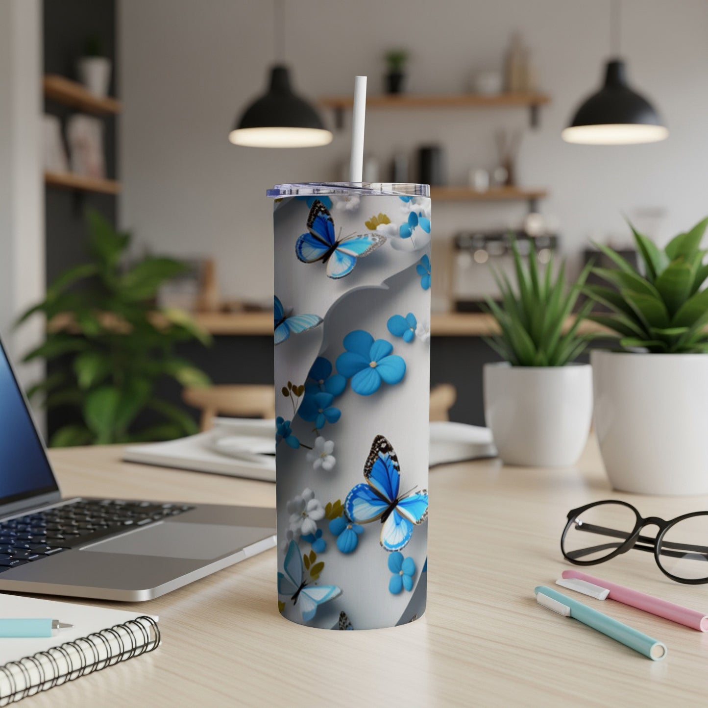 Blue butterflies and white flowers on a light grey skinny tumbler.