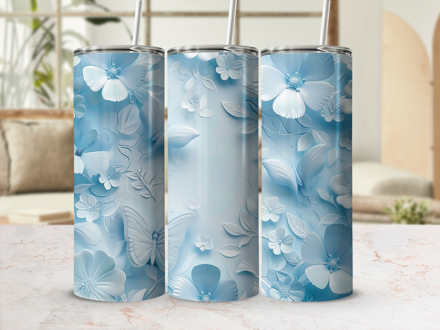 Three blue tumblers with raised floral and butterfly designs.