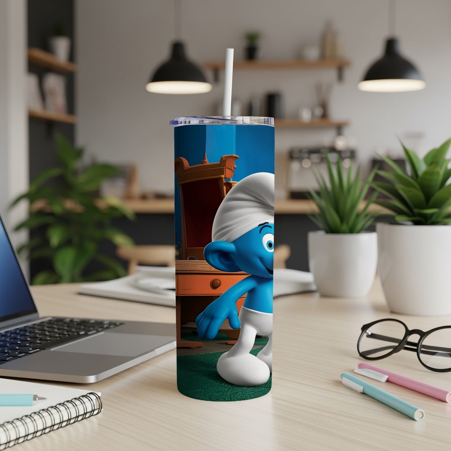 Smurf character on a blue tumbler with white straw, placed on a desk.