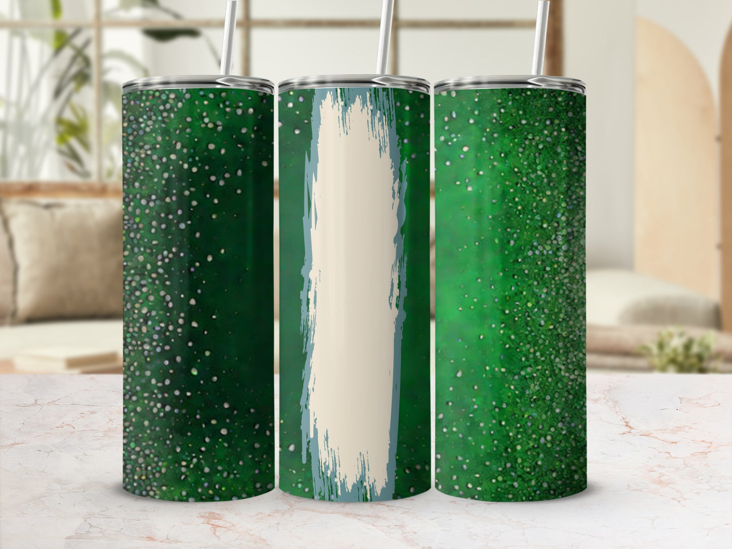 Three green speckled tumblers with straws on a marble surface.