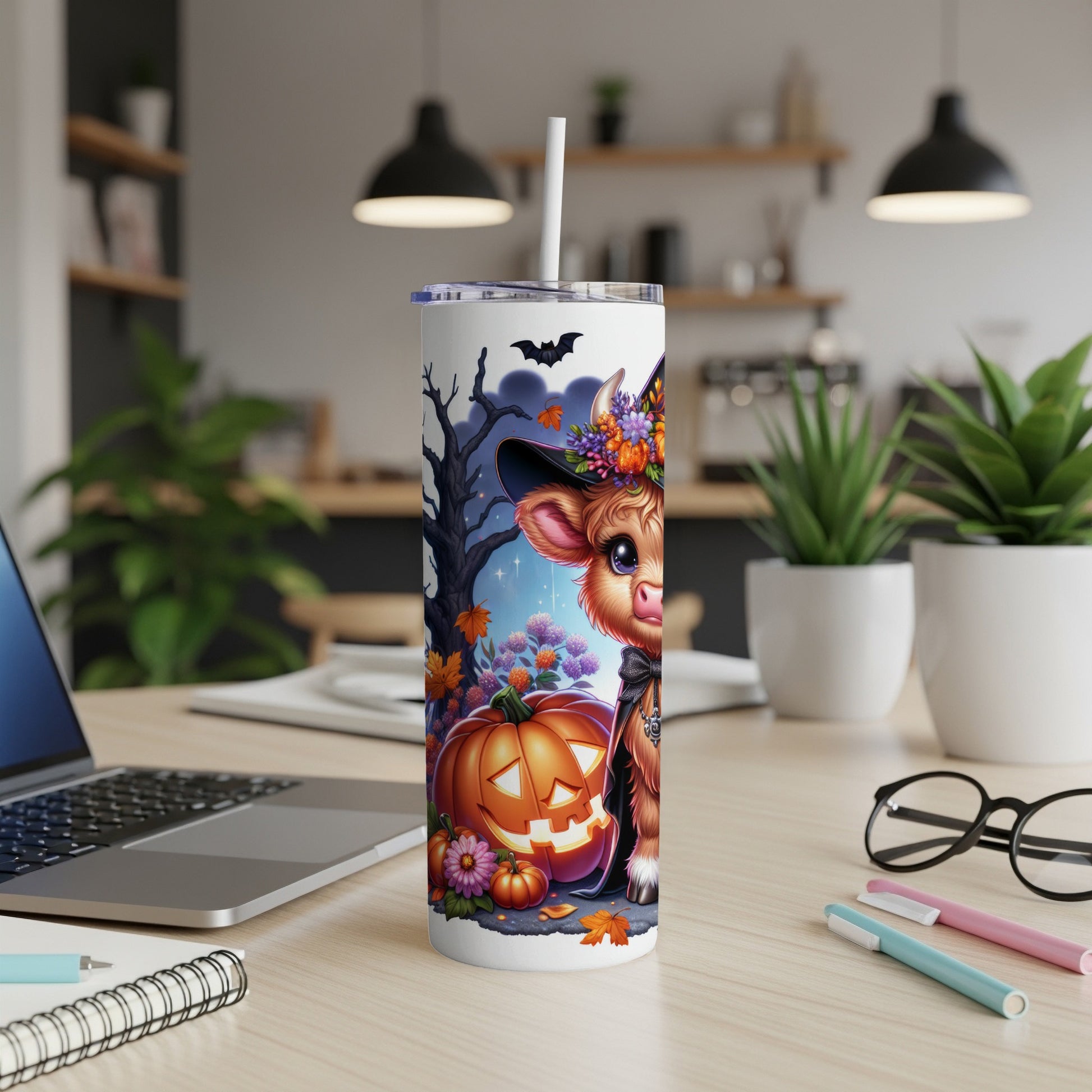 Cow in witch hat with pumpkin and Halloween flowers on a skinny tumbler.