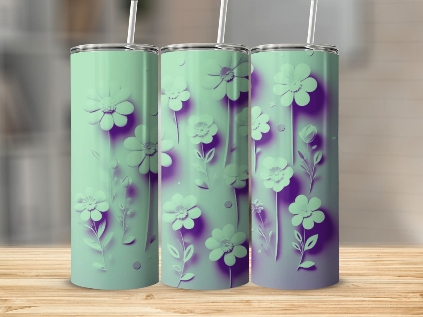Three mint green tumblers with purple floral designs displayed on a wooden surface.