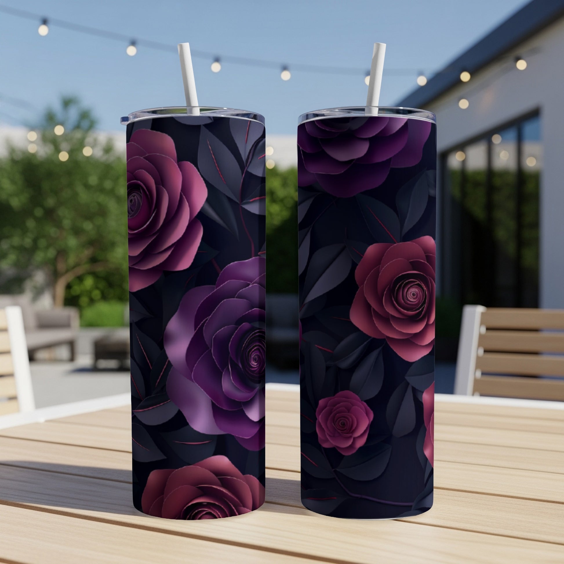 Two tumblers with dark purple and red floral patterns on a table.