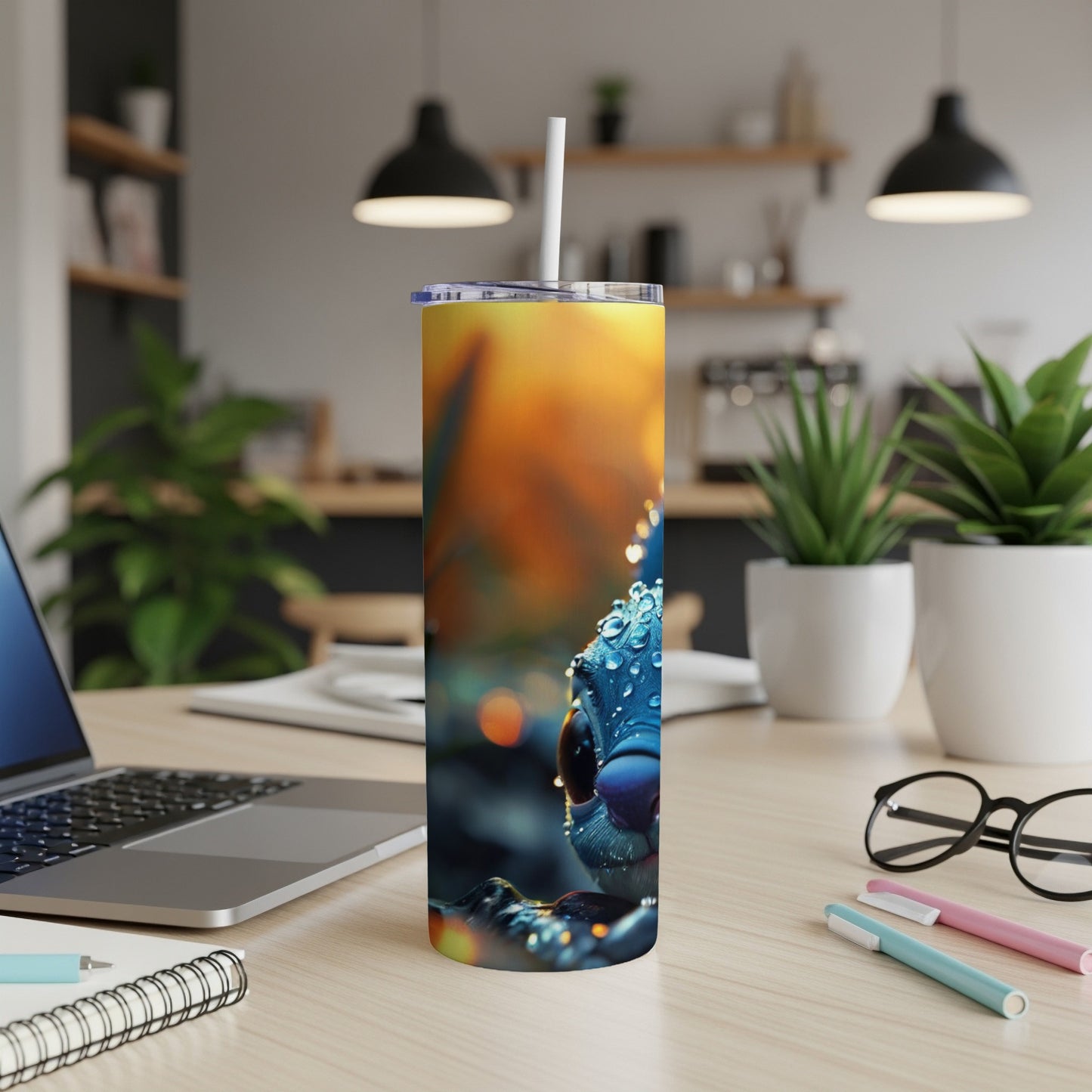 Blue cartoon creature with water droplets on a yellow and orange background on a tumbler.