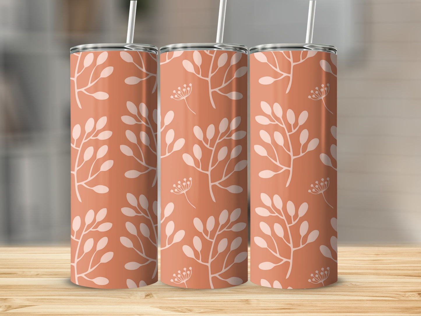 Three coral tumblers with a white floral branch pattern.