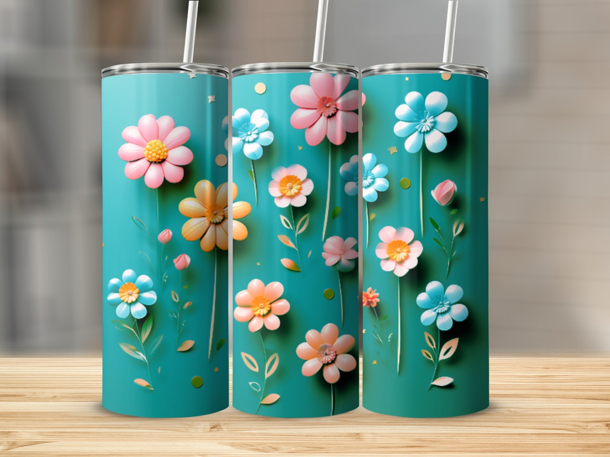 Three teal tumblers with colorful floral patterns and white straws.