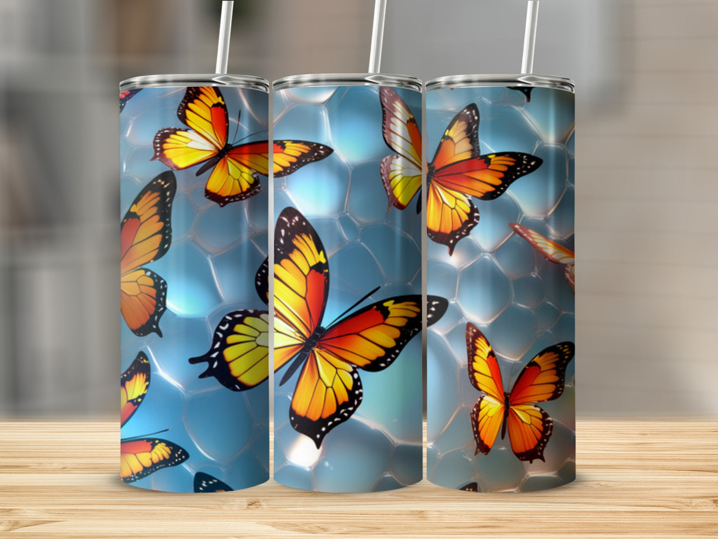 Three tumblers with colorful butterfly designs on a bubbly blue background.