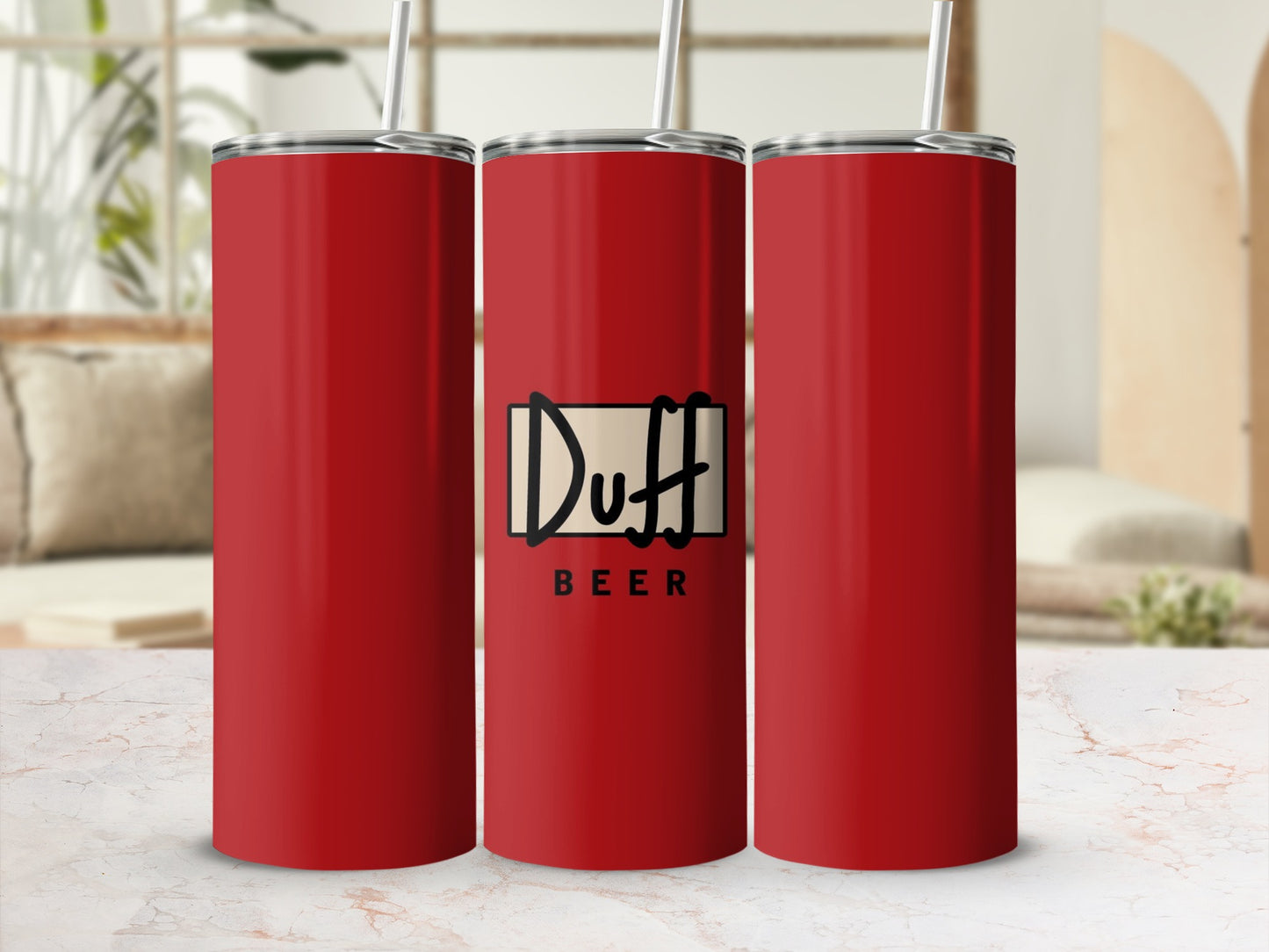 Three red Duff Beer tumblers with straws, lined up on a table.