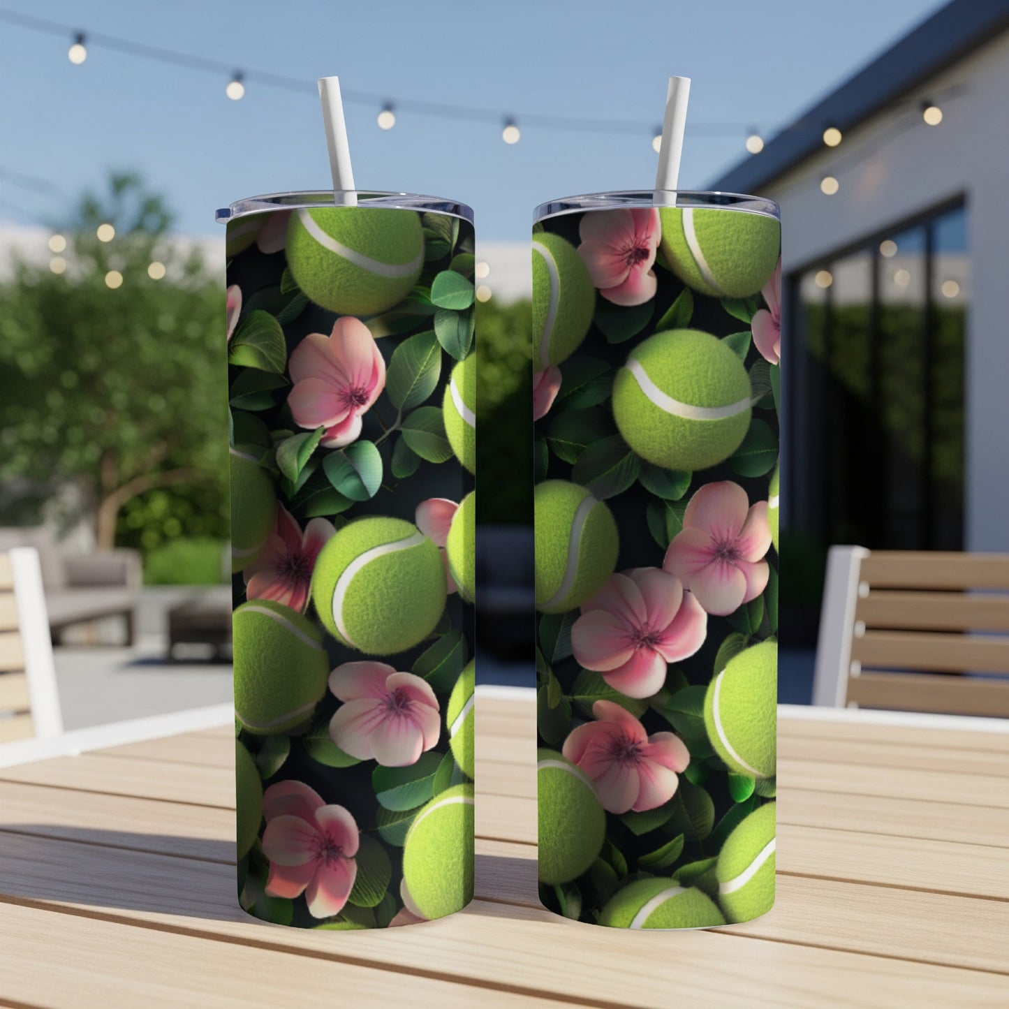 Two tumblers with tennis balls and pink flowers on a wooden table.
