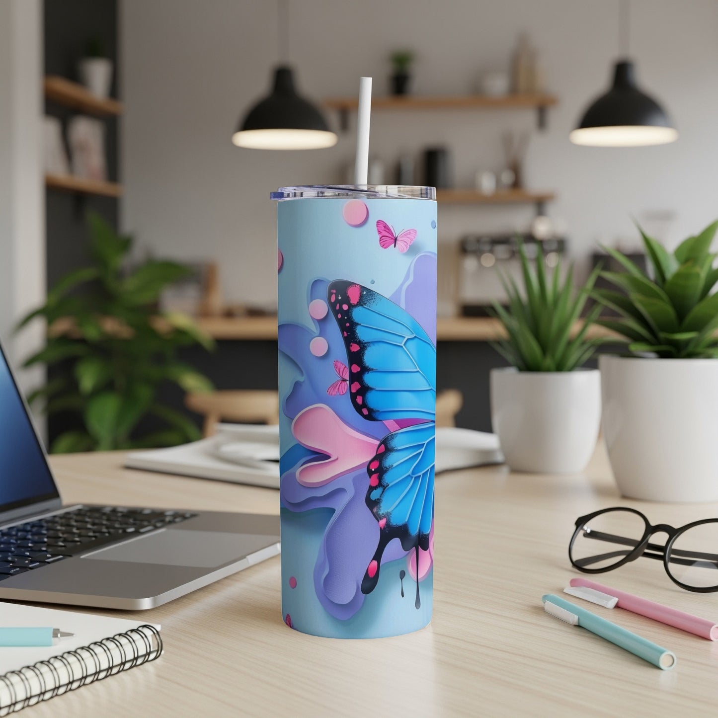 Blue butterfly on a pastel patterned skinny tumbler with a straw.