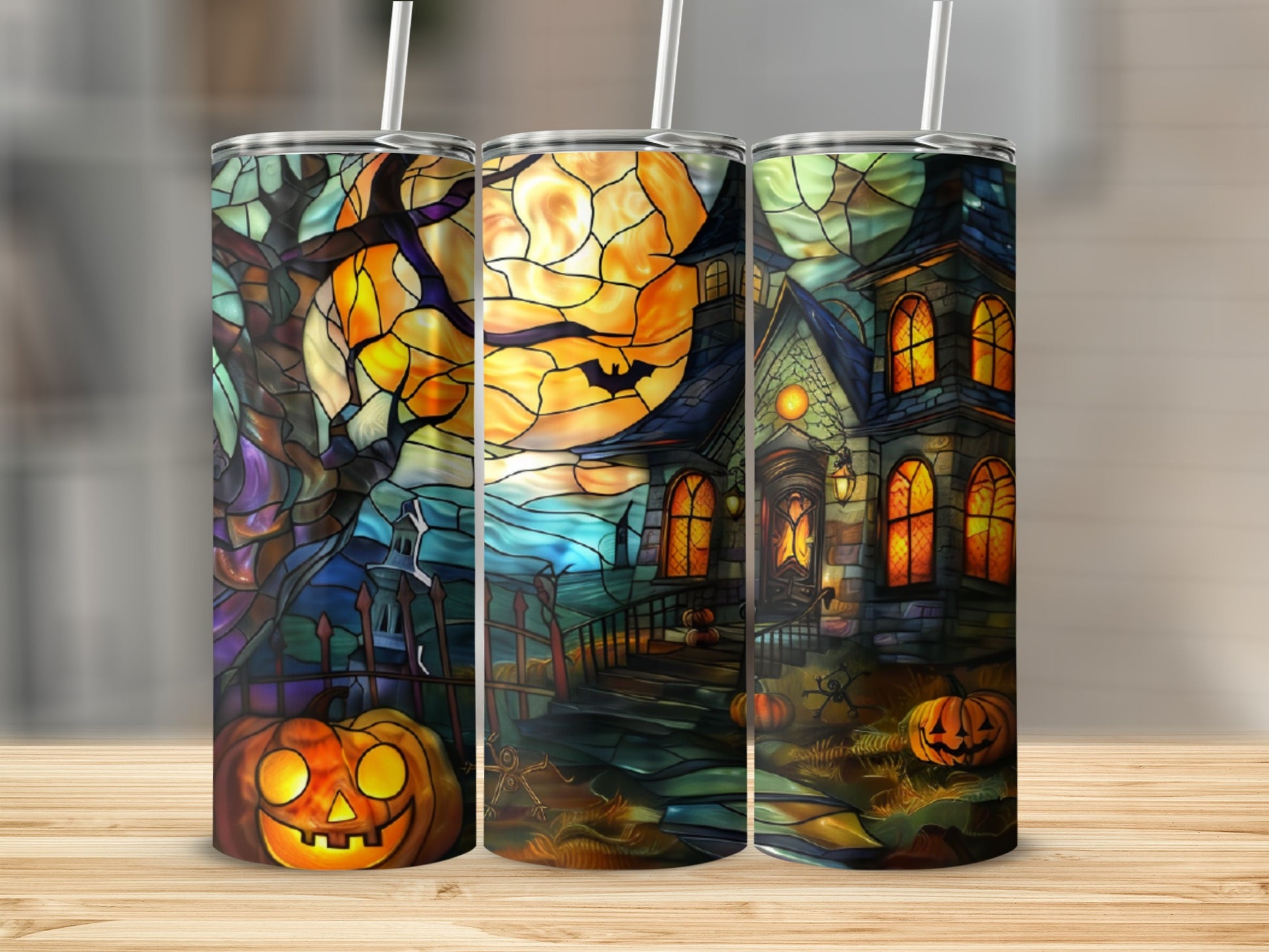 Three Halloween-themed tumblers with stained-glass style designs of pumpkins and haunted houses.