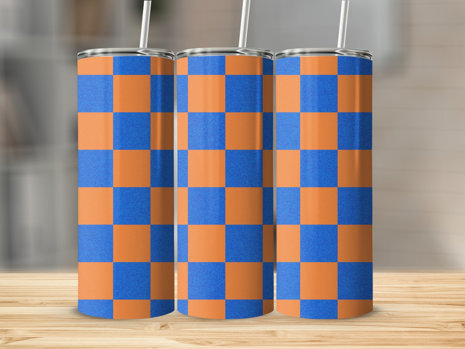 Three tumblers with orange and blue checkered pattern on a wooden surface.