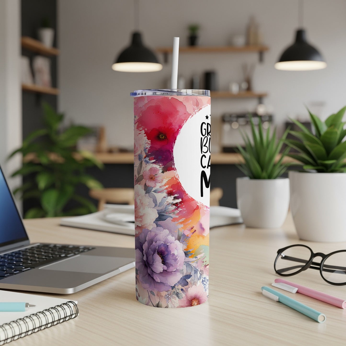 Floral tumbler with "Great Big Cuddle" text on a desk with laptop.