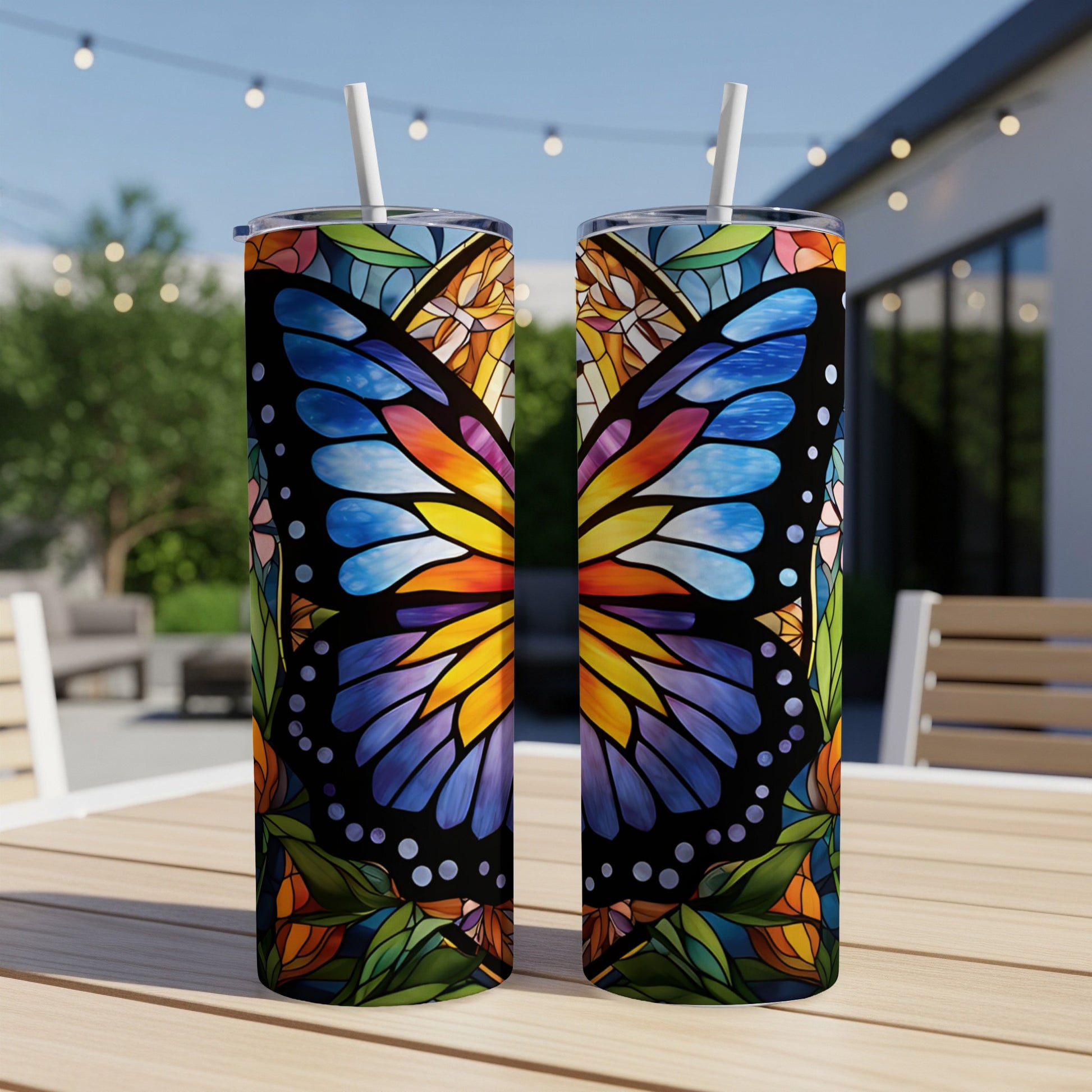 Two tumblers with a stained-glass butterfly design sit on a table.