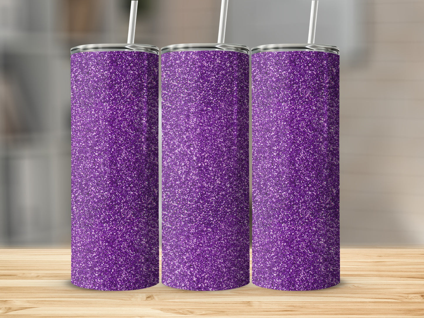 Three tall purple glitter tumblers with white straws stand on a wooden surface.