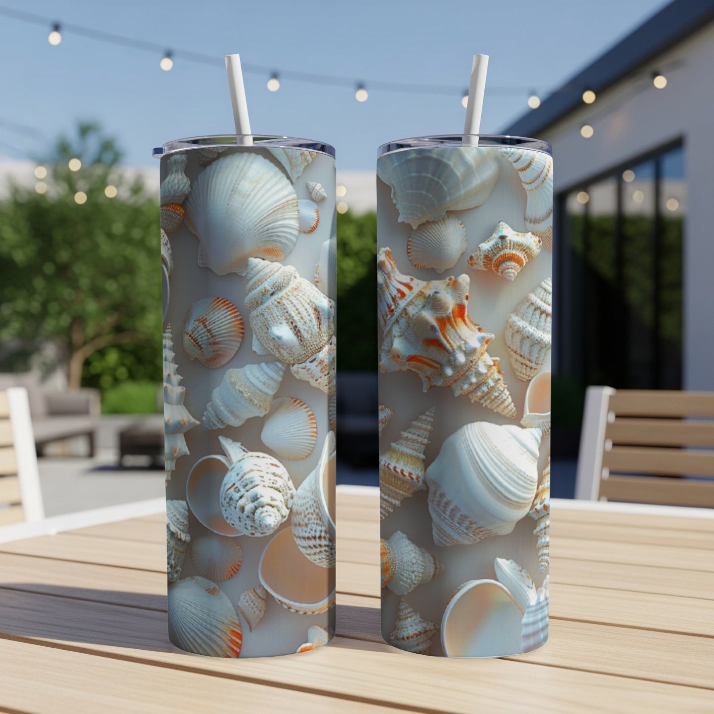 Two tall tumblers with seashell patterns, set on a table outdoors.